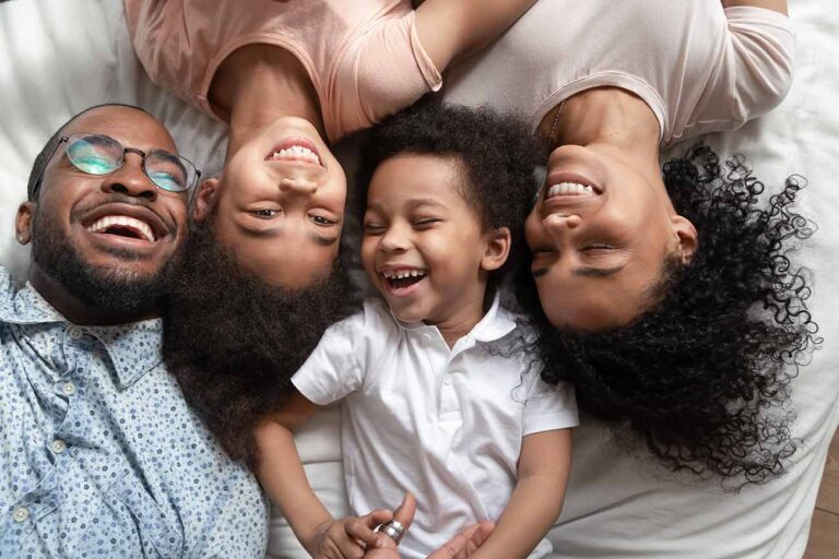 Family Laughing on a Hotel Bed